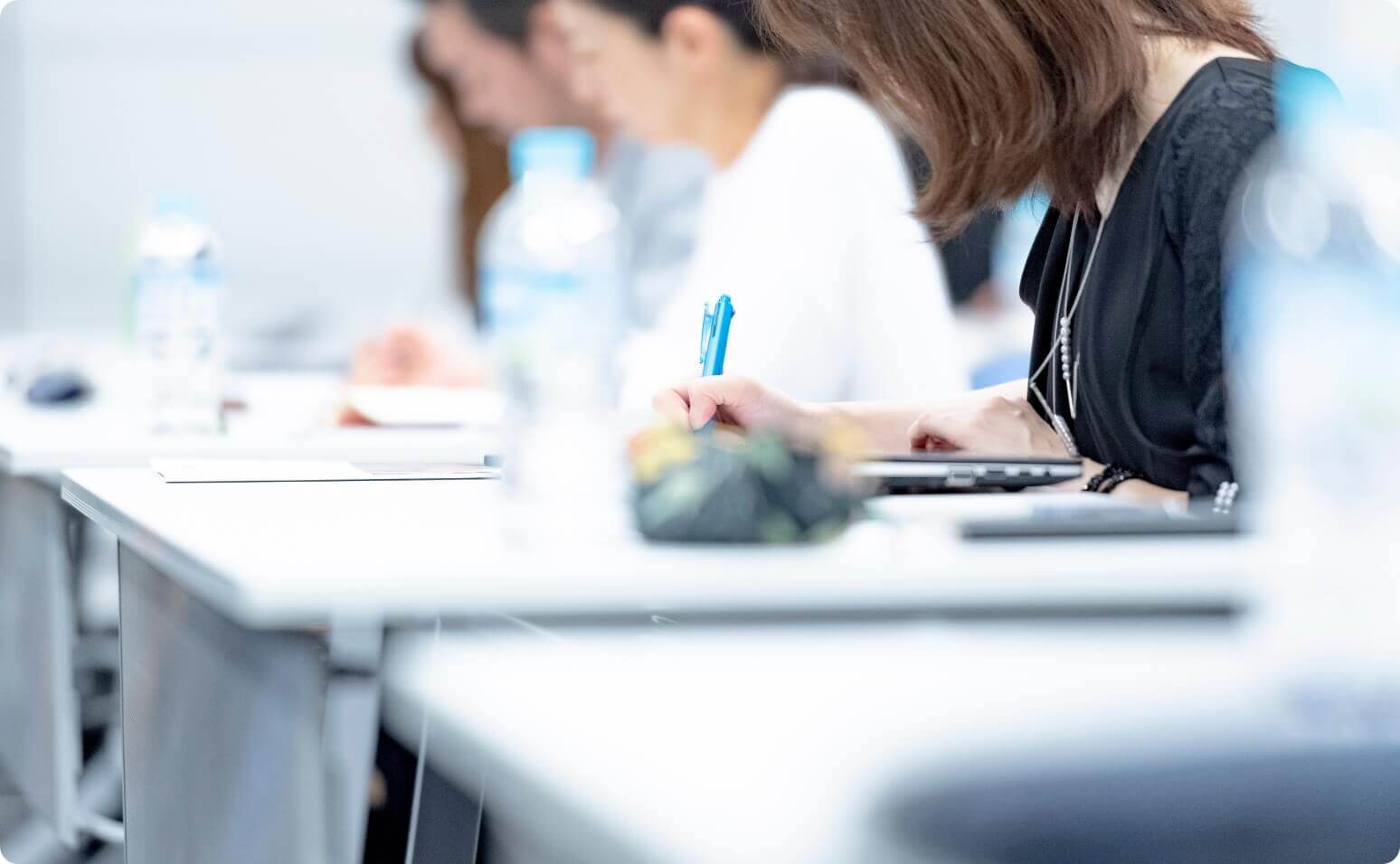 セミナー会場で講師の話を聞く参加者たちの後ろ姿