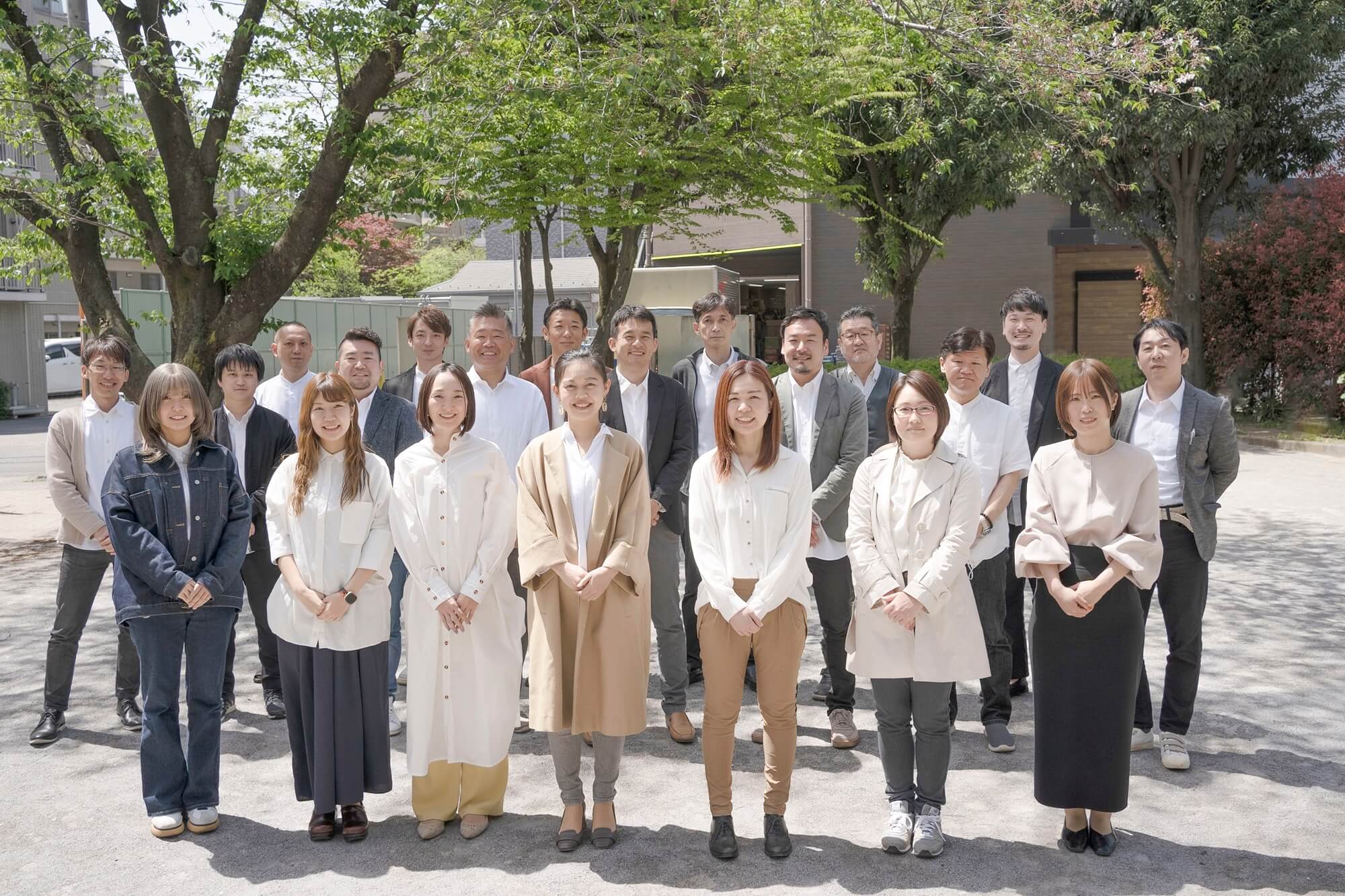 秋の並木道を歩く5人のスタッフ